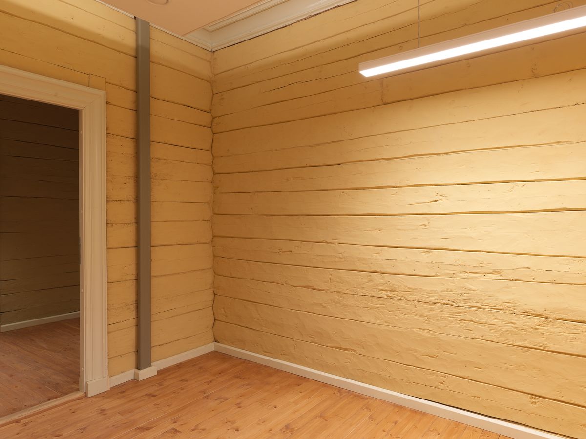 Foto av et arbeidsrom i første etasje, med synlig tømmervegger.