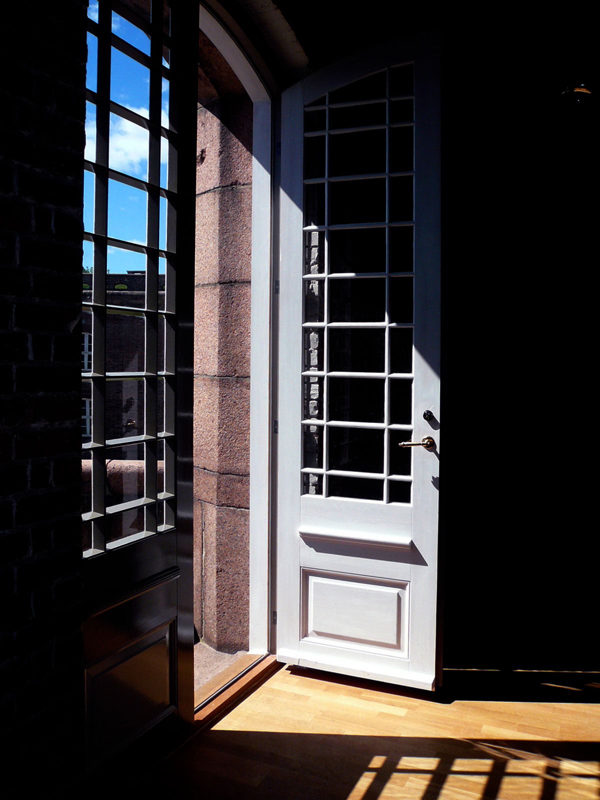 Stemningsfoto av sollys treffer vinduet og lager mønter i rommet. Åpen balkongdør.