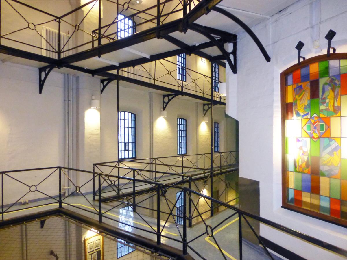 Foto som viser innsiden av fengslet, en hall med mesaniner i ulike plan. Hvite vegger med flotte store vinduer.