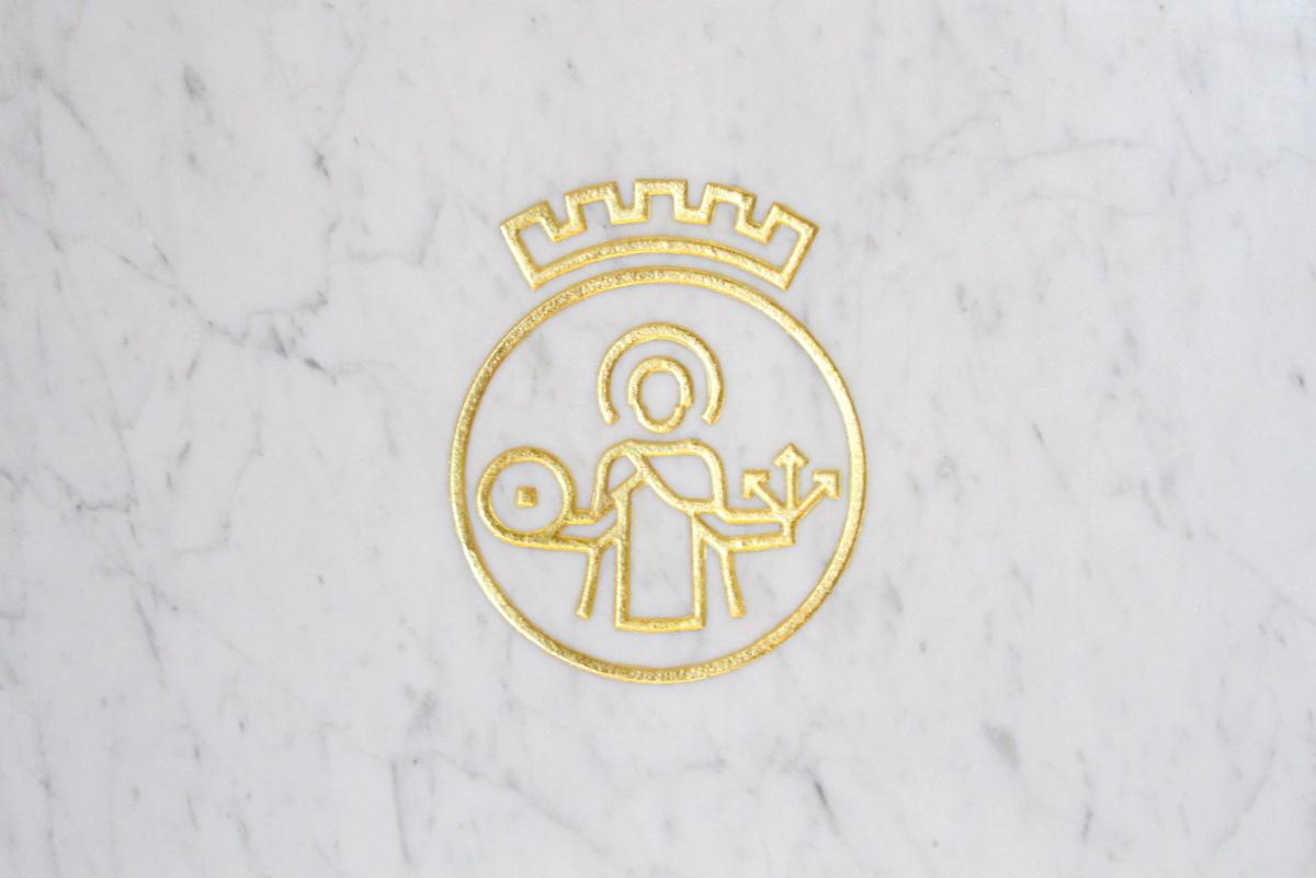Detaljfoto av skjermstativ. Oslo logo er frest ut i marmoren, malt i gullfarge. 