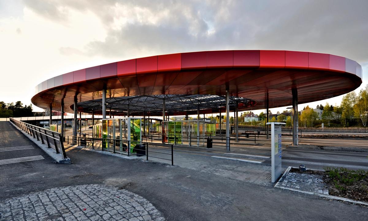 Foto av terminalen med stort rødt ellipseformet tak.