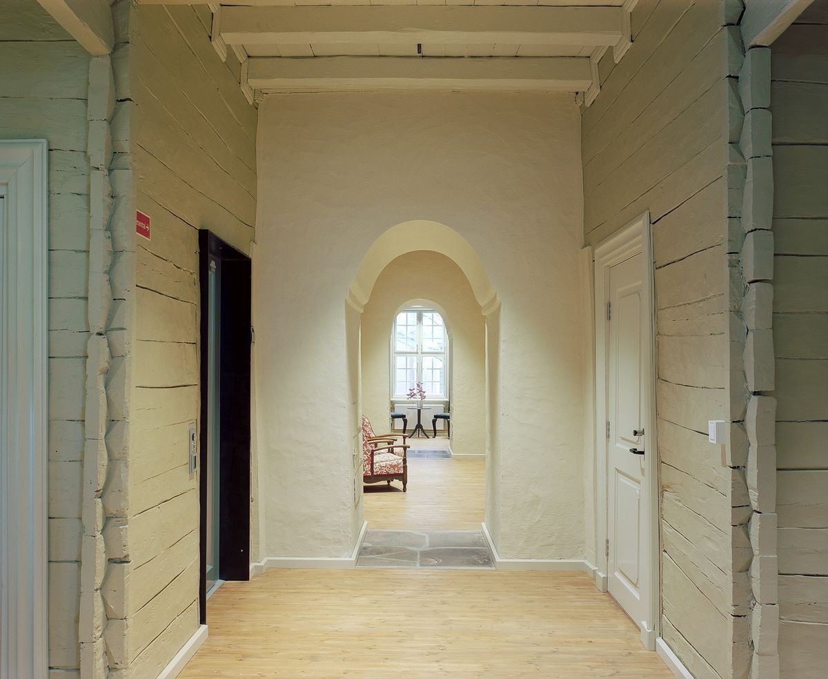 Foto av korridor i første etasje, vegger i historisk korrekt beige farge. 