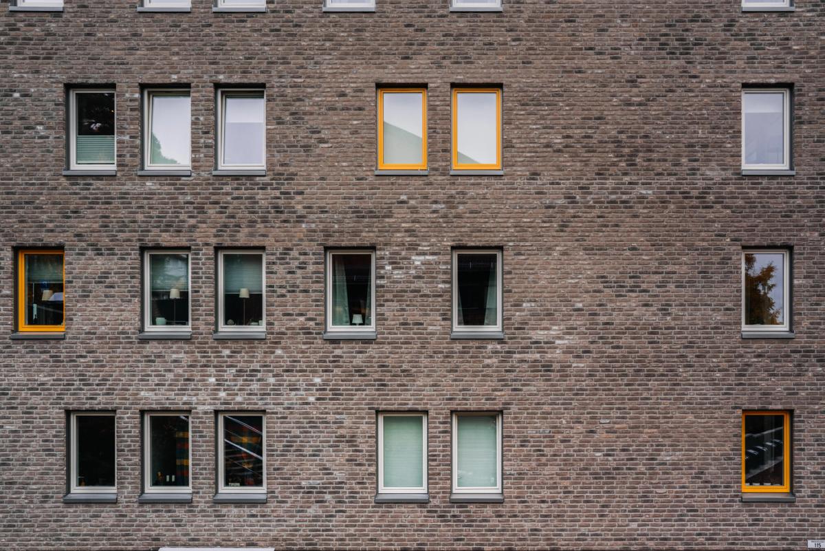 Fasadefoto av vinduer der noen er hvite, mens andre vinduer er gule. 