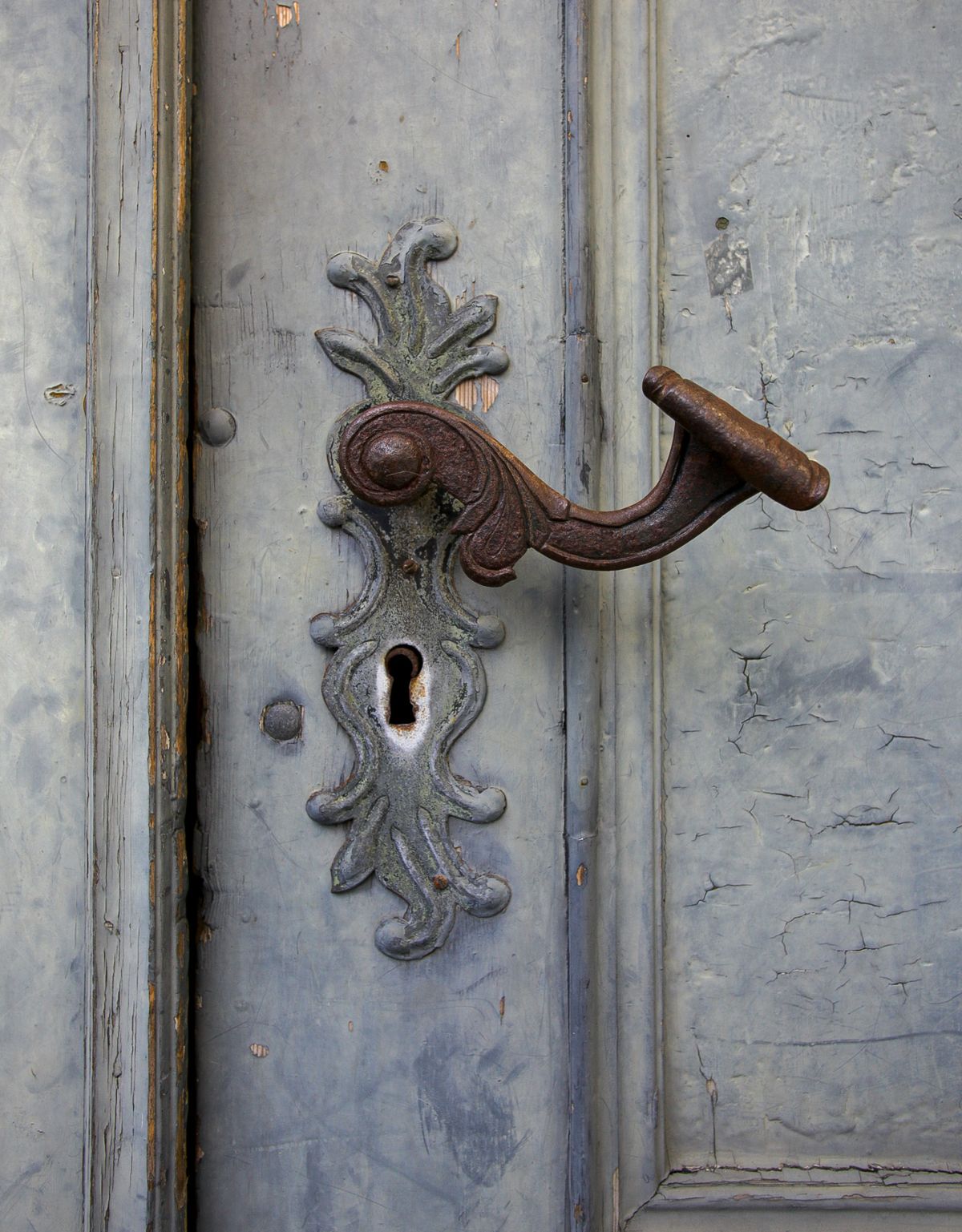 Foto av rustent dørhåndtak med fine detaljer.