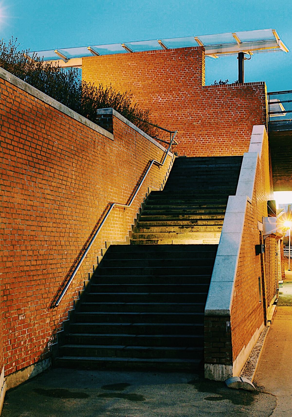 Foto av trapp opp til t-bane plattform fotografert på kveldstid. God utebelysning