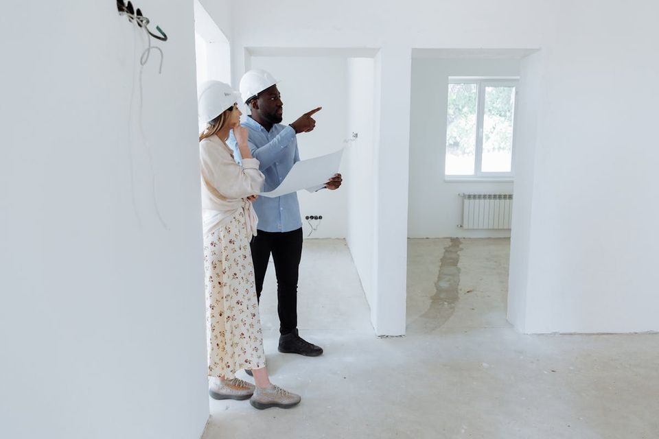 General contractor and homeowner walking through a finished new-construction home with a punch-list clipboard