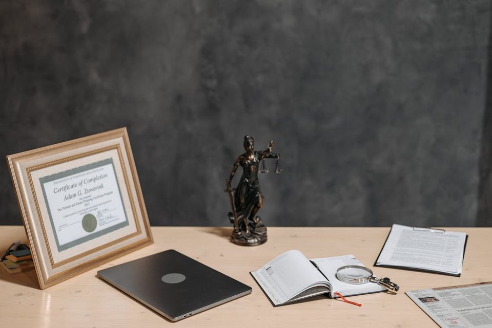 Stack of inherited property documents including deed, death certificate, will, and property tax records organized on a desk