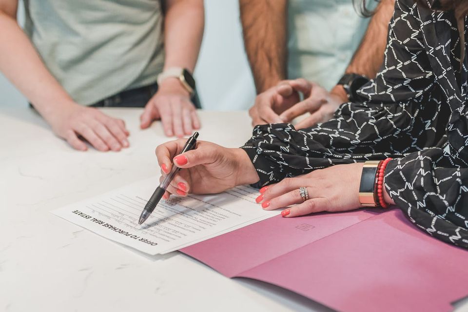Buyer and seller signing real estate disclosure documents at a table