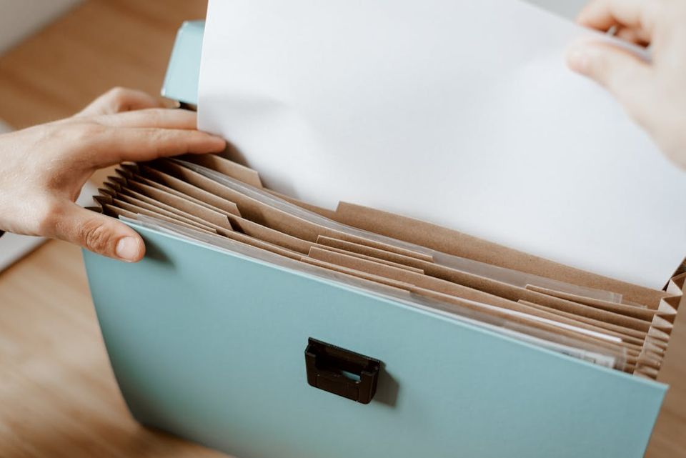 Organized binder with home improvement permits, receipts, and before-and-after renovation photos