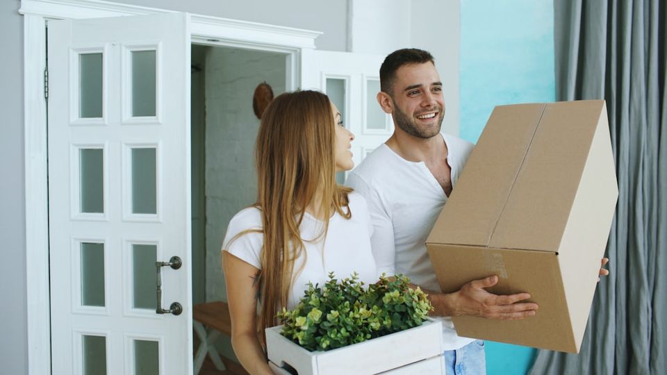 New homeowner couple unpacking boxes in their new house during the first week