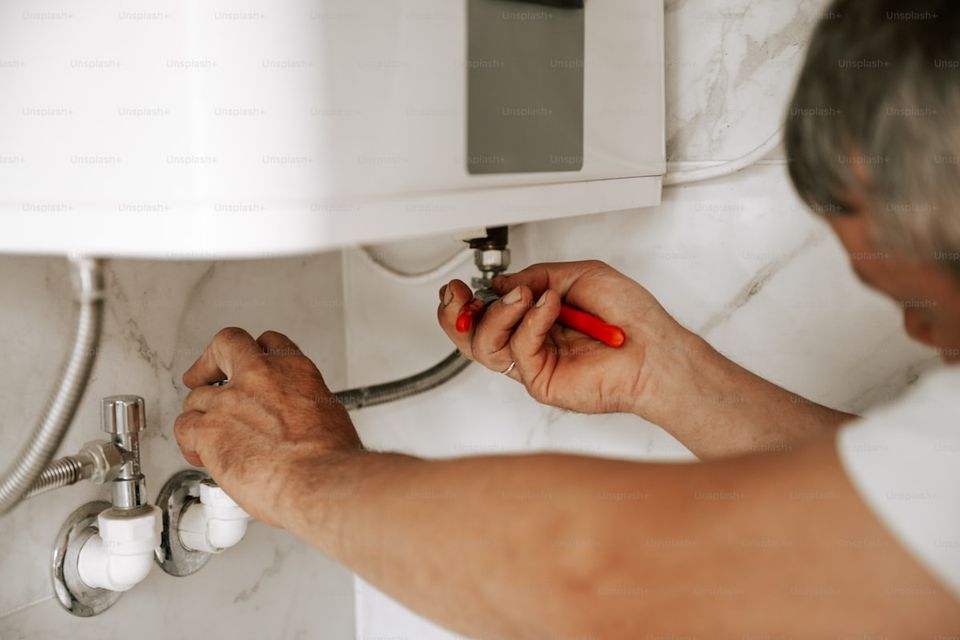 Water heater sediment flushing process with garden hose draining into bucket