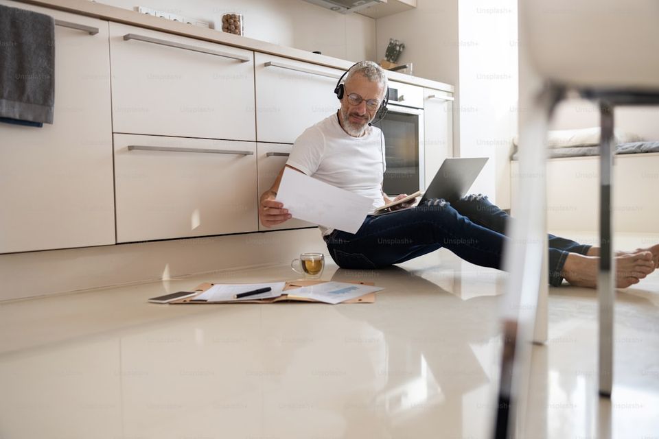 A homeowner reviewing HVAC service records at the kitchen table with a laptop open