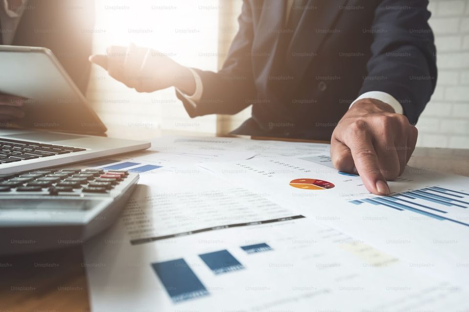 Real estate investor analyzing property financial documents and inspection reports at desk