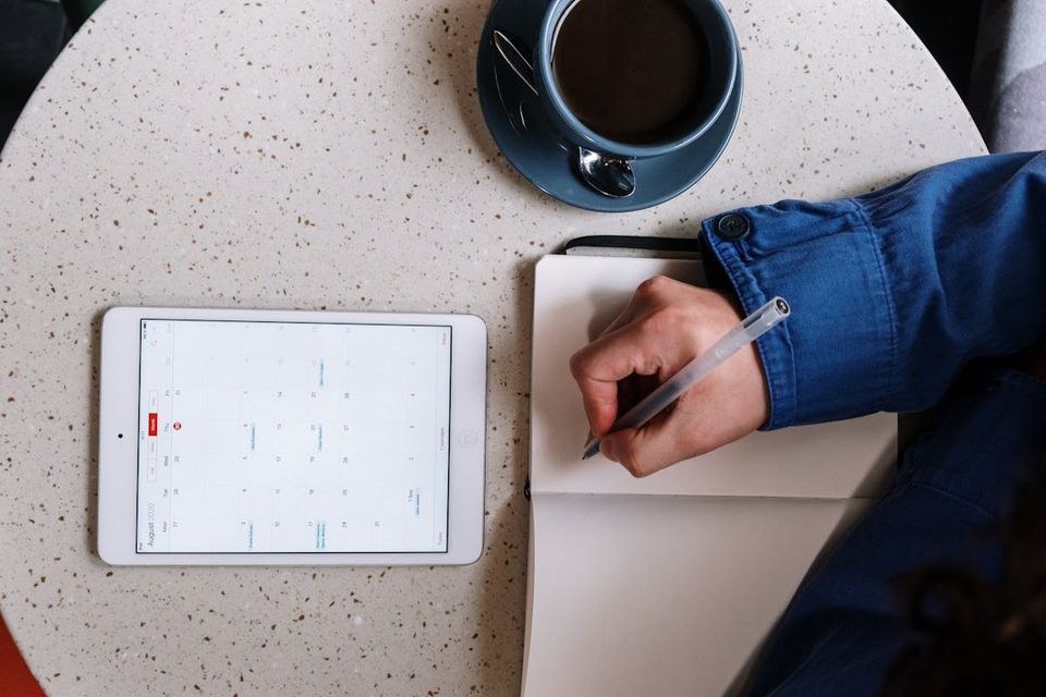 Homeowner reviewing a home maintenance schedule on a tablet at the kitchen counter