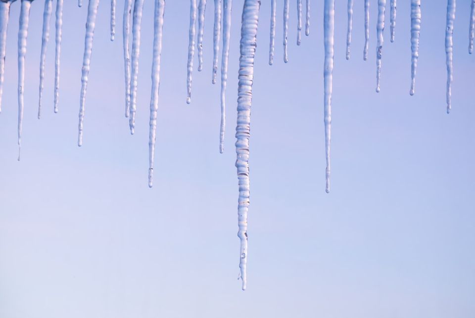 Ice dam forming at the edge of a snow-covered roof line