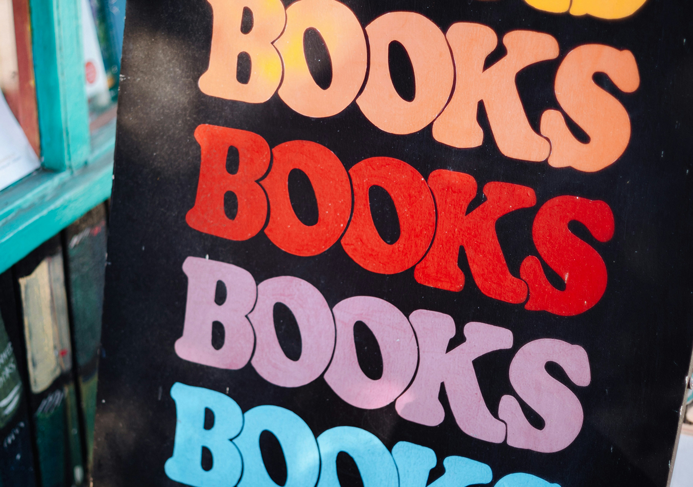 Яркий плакат с повторяющимся словом «Books». (Värikäs juliste, jossa lukee toistuvasti “Books”.)