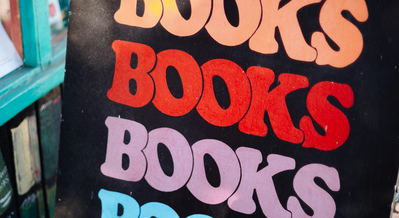 Яркий плакат с повторяющимся словом «Books». (Värikäs juliste, jossa lukee toistuvasti “Books”.)