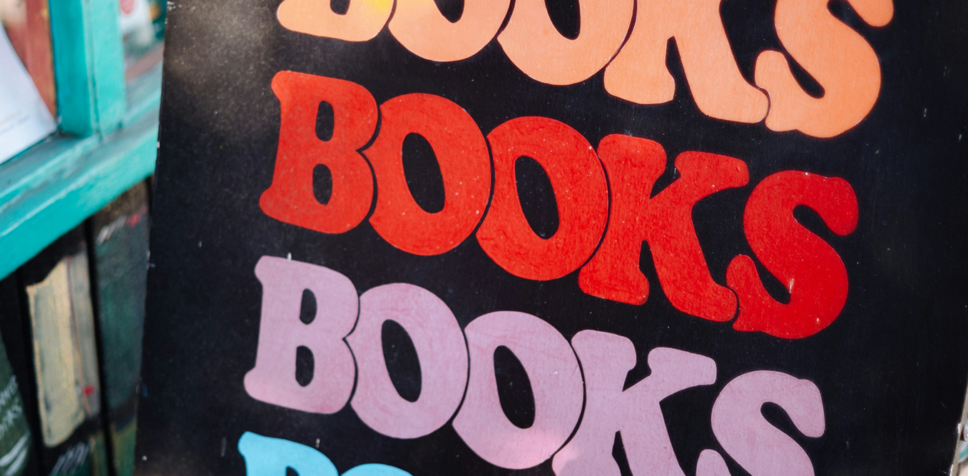 Яркий плакат с повторяющимся словом «Books». (Värikäs juliste, jossa lukee toistuvasti “Books”.)