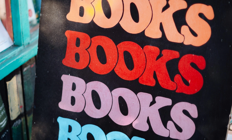 Яркий плакат с повторяющимся словом «Books». (Värikäs juliste, jossa lukee toistuvasti “Books”.)