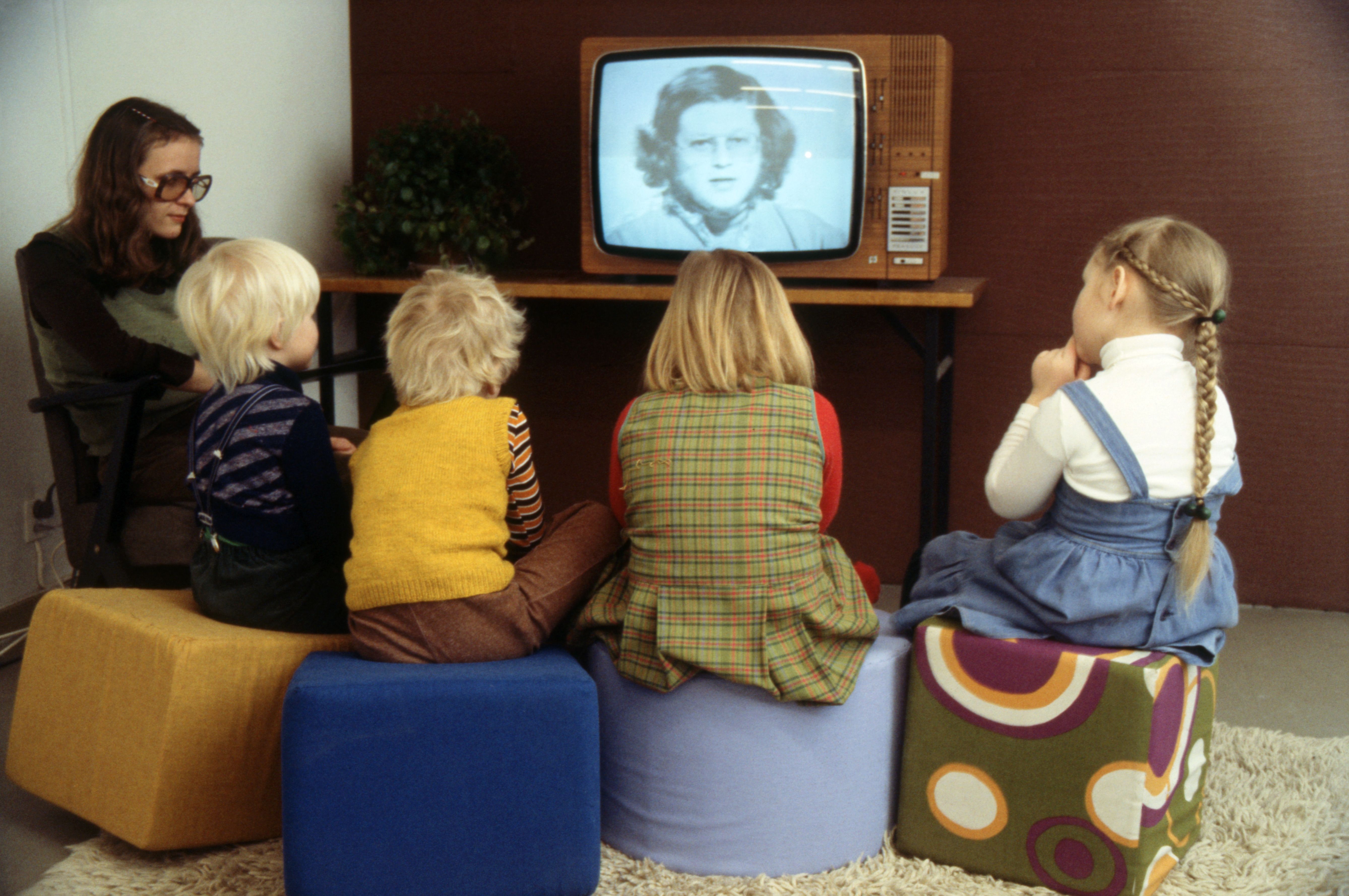 Женщина и дети смотрят детскую передачу по телевизору (Nainen ja lapset katsovat televisiosta lastenohjelmaa)