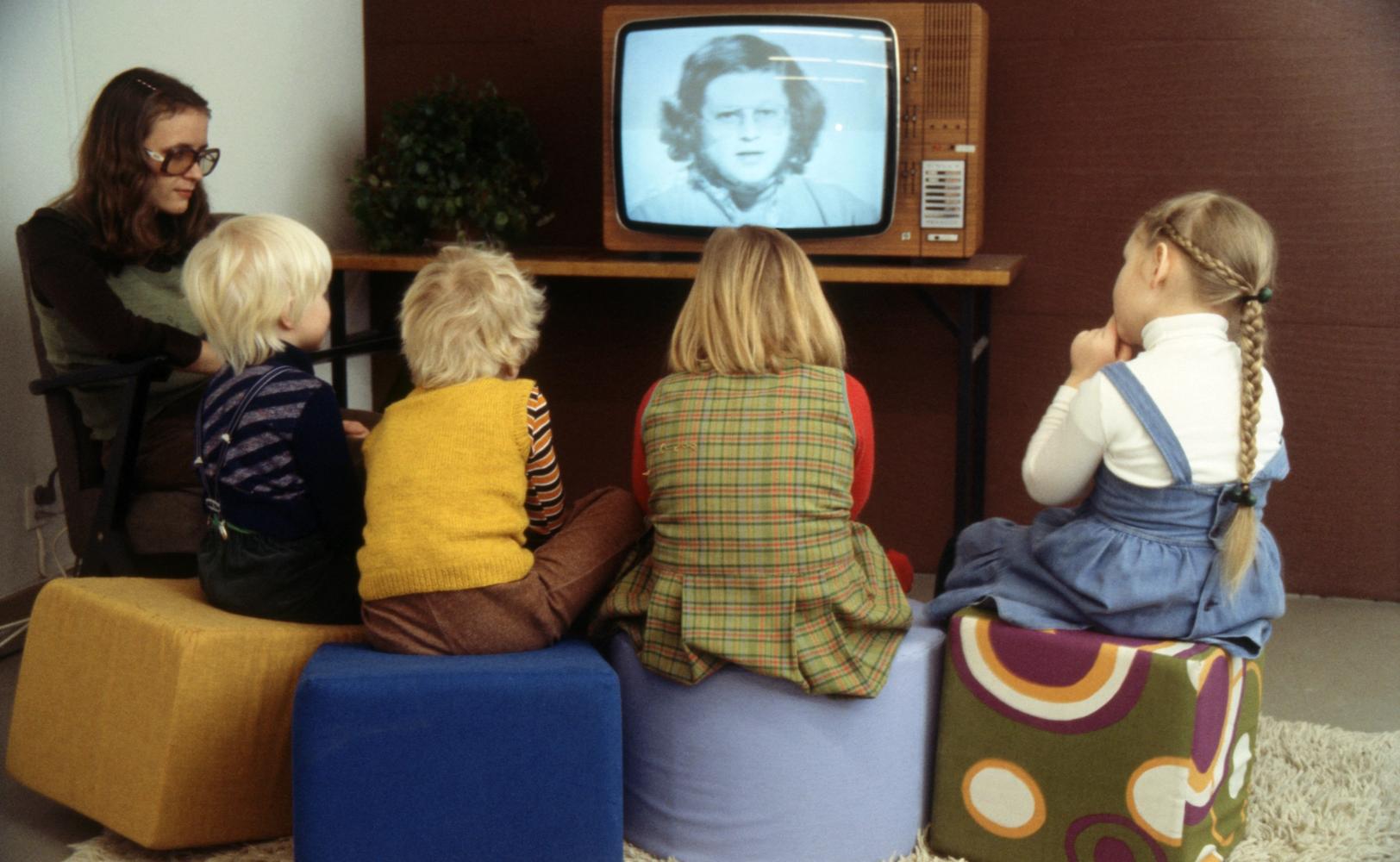 Женщина и дети смотрят детскую передачу по телевизору (Nainen ja lapset katsovat televisiosta lastenohjelmaa)