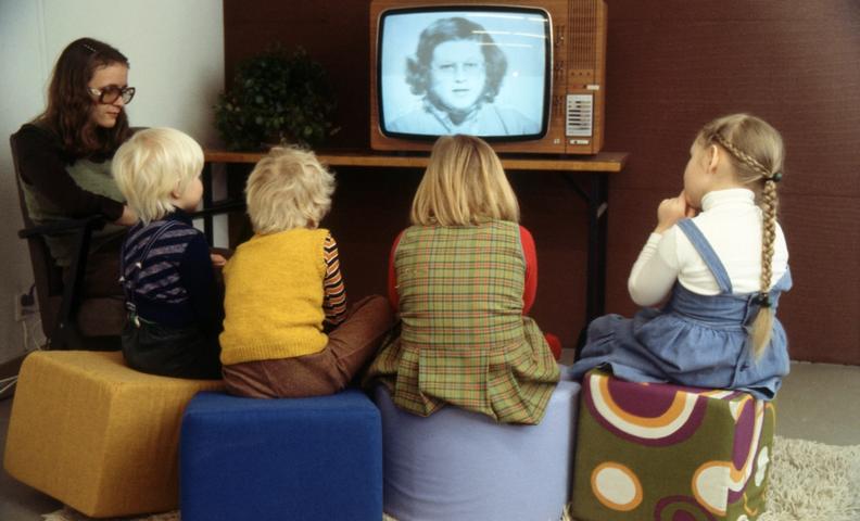 Женщина и дети смотрят детскую передачу по телевизору (Nainen ja lapset katsovat televisiosta lastenohjelmaa)