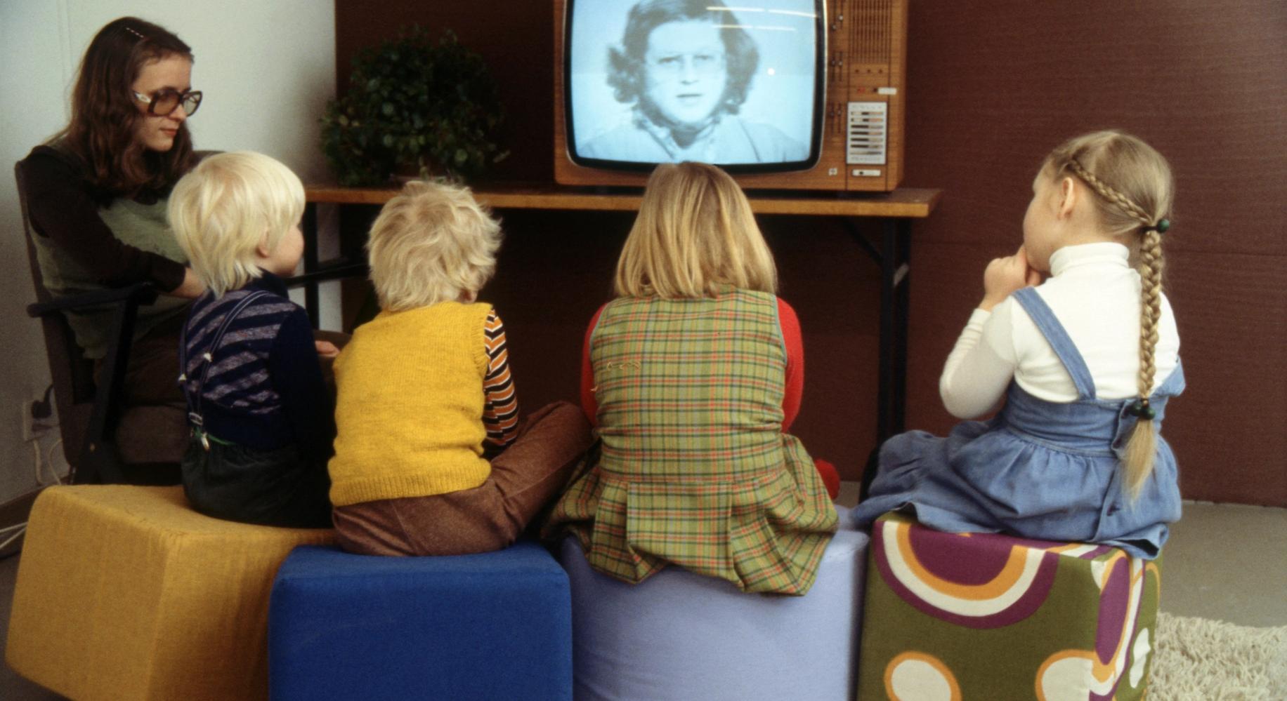 Женщина и дети смотрят детскую передачу по телевизору (Nainen ja lapset katsovat televisiosta lastenohjelmaa)