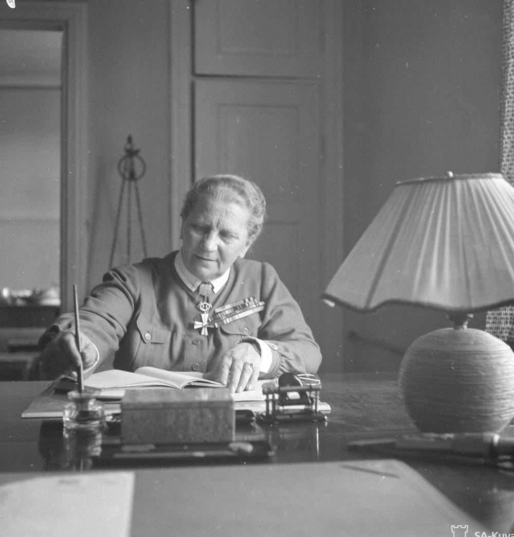 Фанни Луукконен в униформе пишет за столом (Fanni Luukkonen univormussa kirjoittamassa pöydän ääressä)