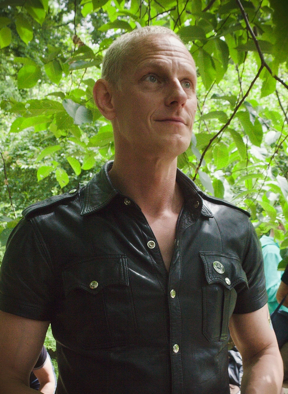 Hymyilevä mies sateenkaariväristen valokehien edessä