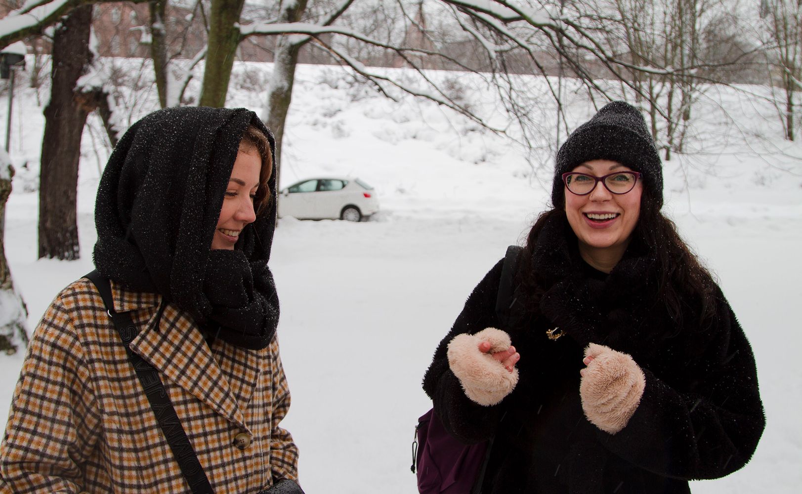 Две женщины улыбаются на фоне зимнего пейзажа (Kaksi naista hymyilevät, taustalla talvinen maisema)