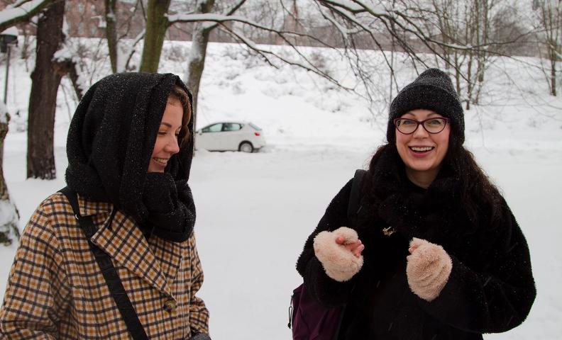 Две женщины улыбаются на фоне зимнего пейзажа (Kaksi naista hymyilevät, taustalla talvinen maisema)