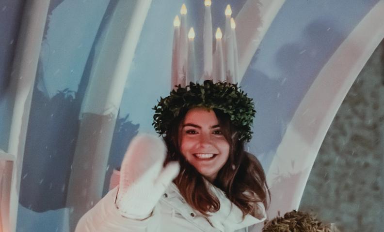 Люсия 2023 Мадлен Аморосо улыбается и машет рукой (Vuoden 2023 Lucia-neito Madeleine Amoroso heiluttaa yleisölle hymyillen)