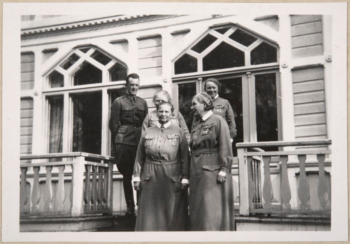 Люди в униформах стоят на крыльце дома (Ihmisiä univormuissa seisoo talon portailla)