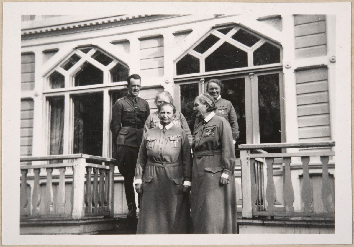 Люди в униформах стоят на крыльце дома (Ihmisiä univormuissa seisoo talon portailla)