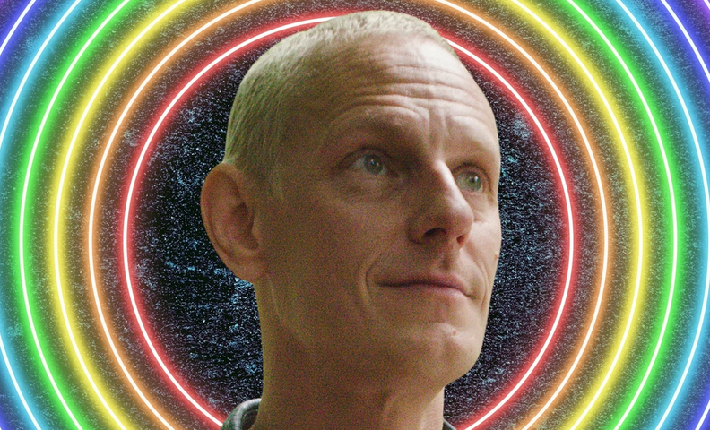 Hymyilevä mies sateenkaariväristen valokehien edessä