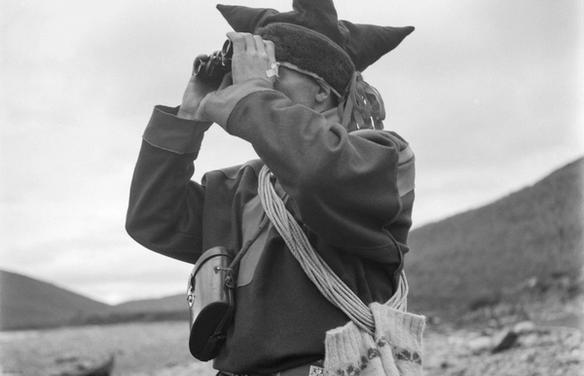 Человек в саамском костюме смотрит в бинокль (Saamenpukuun pukeutunut mies katsoo kiikareilla maisemaa)