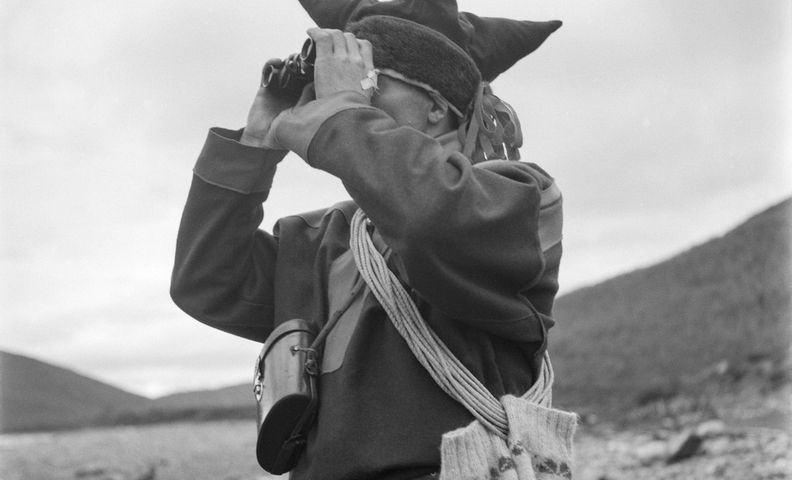 Человек в саамском костюме смотрит в бинокль (Saamenpukuun pukeutunut mies katsoo kiikareilla maisemaa)