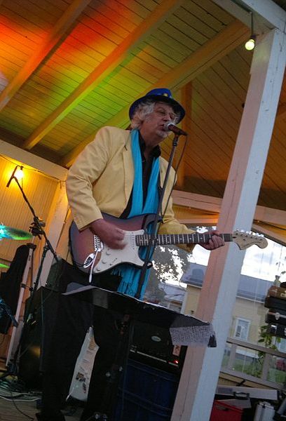 Музыкант Хассе Валли поет в микрофон и играет на электрогитаре (Muusikko Hasse Walli laulaa mikrofoniin ja soittaa sähkökitaraa)