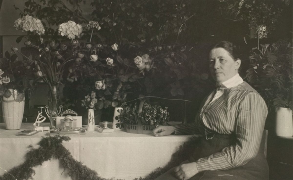 Фотография Миины Силланпяя, сидящей за столом (Kuva Miina Sillanpäästä istumassa ruokapöydän ääressä)