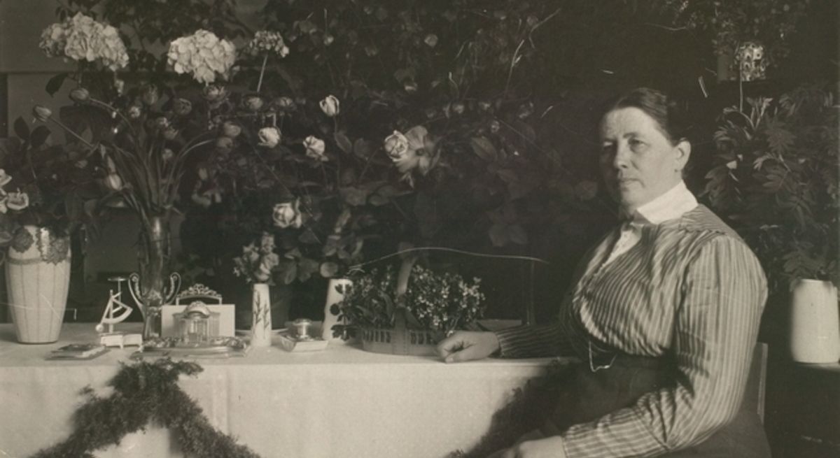 Фотография Миины Силланпяя, сидящей за столом (Kuva Miina Sillanpäästä istumassa ruokapöydän ääressä)