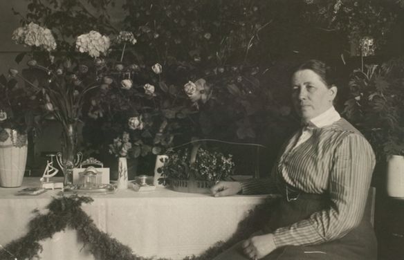 Фотография Миины Силланпяя, сидящей за столом (Kuva Miina Sillanpäästä istumassa ruokapöydän ääressä)