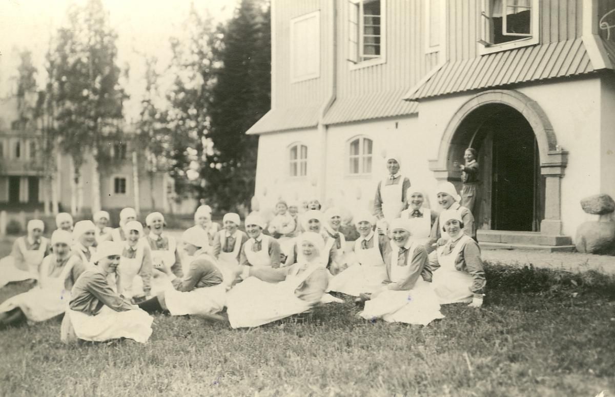 Лотты сидят на траве (Lotta -kurssilaisia istuu nurmikolla)