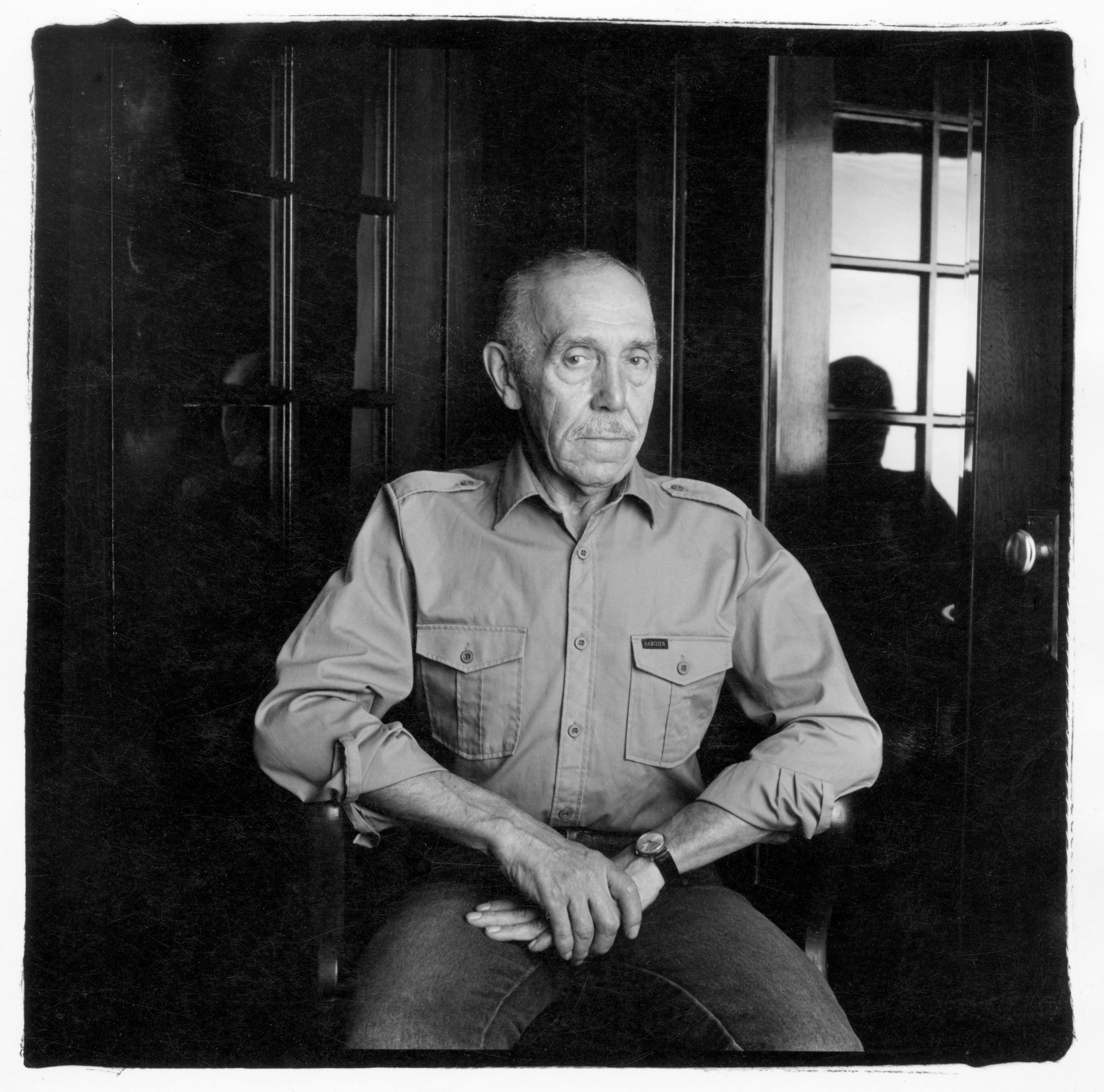 Kuvassa taiteilija Touko Laaksonen eli Tom of Finland istuu nojatuolissa katse katsojaa päin