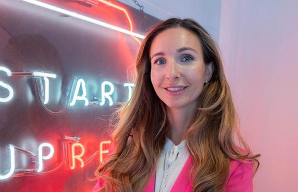 Марина Берзина на фоне баннера организации Startup refugees (Marina Berzina poseeraamassa Startup refugeesin kyltin vieressä)