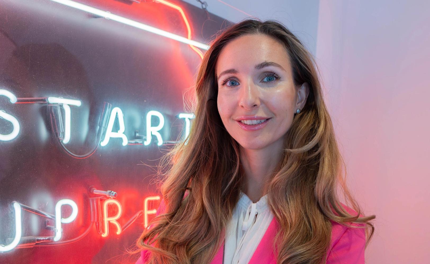 Марина Берзина на фоне баннера организации Startup refugees (Marina Berzina poseeraamassa Startup refugeesin kyltin vieressä)