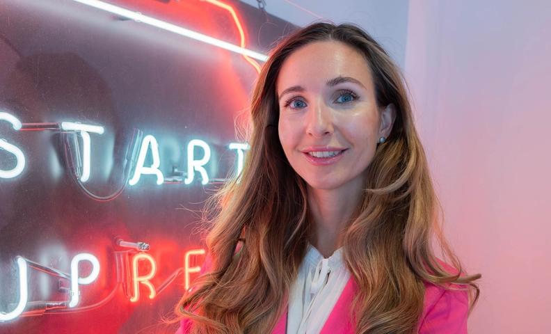 Марина Берзина на фоне баннера организации Startup refugees (Marina Berzina poseeraamassa Startup refugeesin kyltin vieressä)