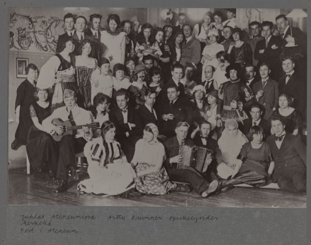 Vanha opiskelijoiden ryhmäkuva, erilaisiin rooliasuihin pukeutuneita opiskelijoita. Keskellä Arttu Brummer.