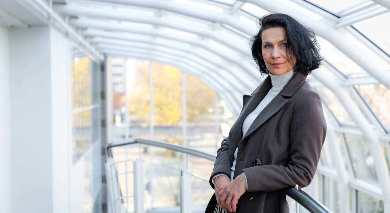 Анна Бабась на фоне стеклянного здания (Anna Babas seisoo  taustallaan lasirakennus)