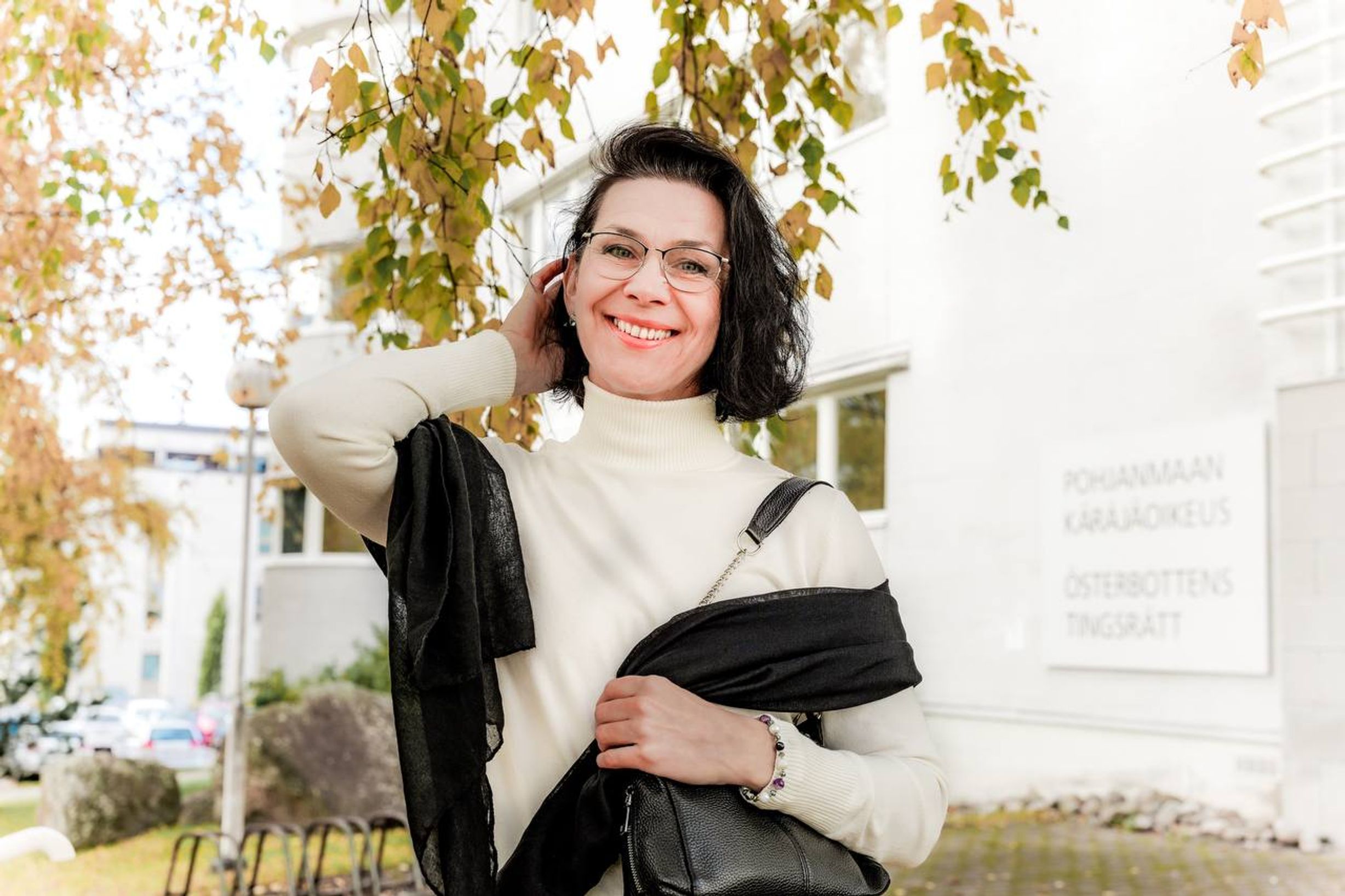 Анна Бабась перед зданием окружного суда Остроботнии (Anna Babas poseeraa taustallaan Pohjanmaan käräjäoikeuden rakennus)