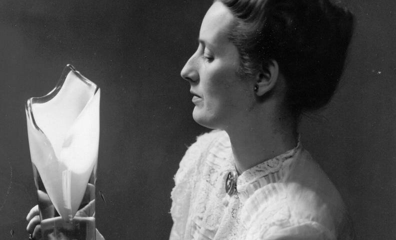 Kuvassa lasimuotoilija Gunnel Nyman maljakko käsissä